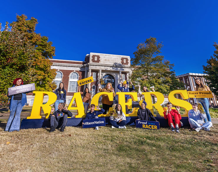Students pose with large "RACERS" letters